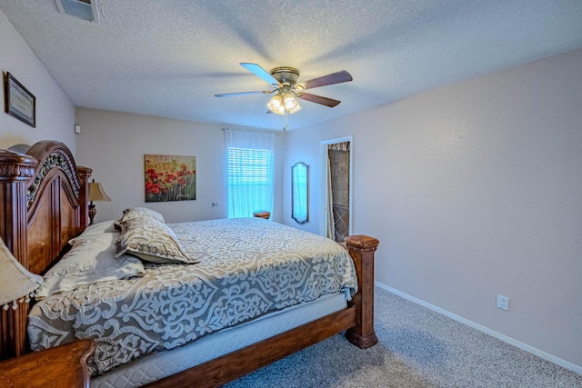 carpeted bedroom featuring visible vents, a textured ceiling, baseboards, and a ceiling fan