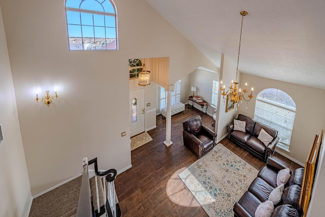 living area featuring a chandelier, dark wood finished floors, high vaulted ceiling, and baseboards