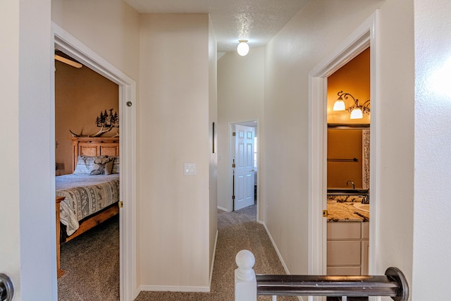 hallway featuring carpet flooring and baseboards