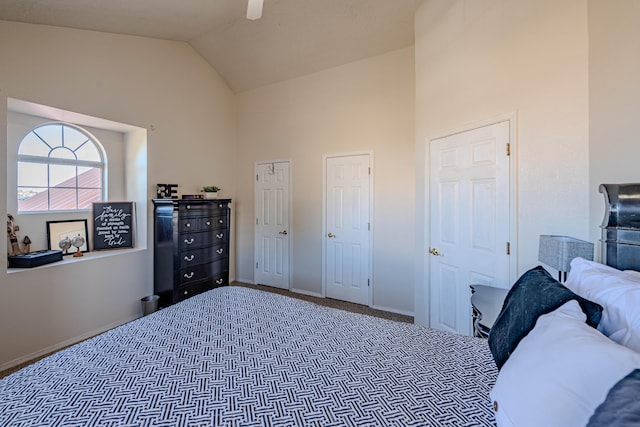 carpeted bedroom with baseboards, high vaulted ceiling, and a ceiling fan