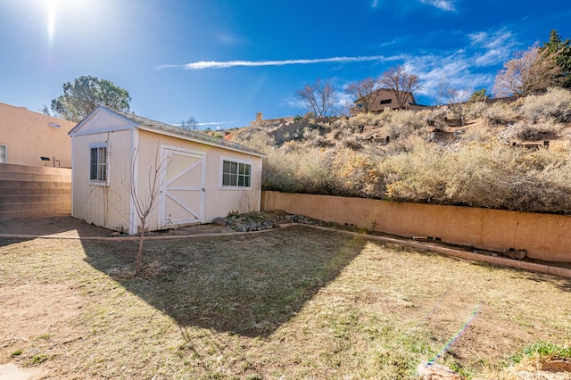 view of yard featuring a fenced backyard, a shed, and an outdoor structure