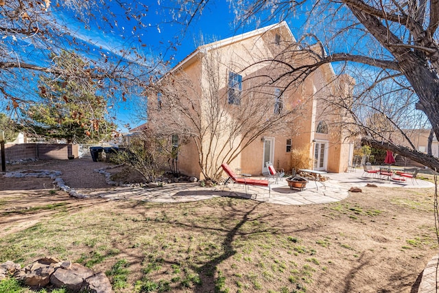 exterior space with a fenced backyard, stucco siding, an outdoor fire pit, and a patio