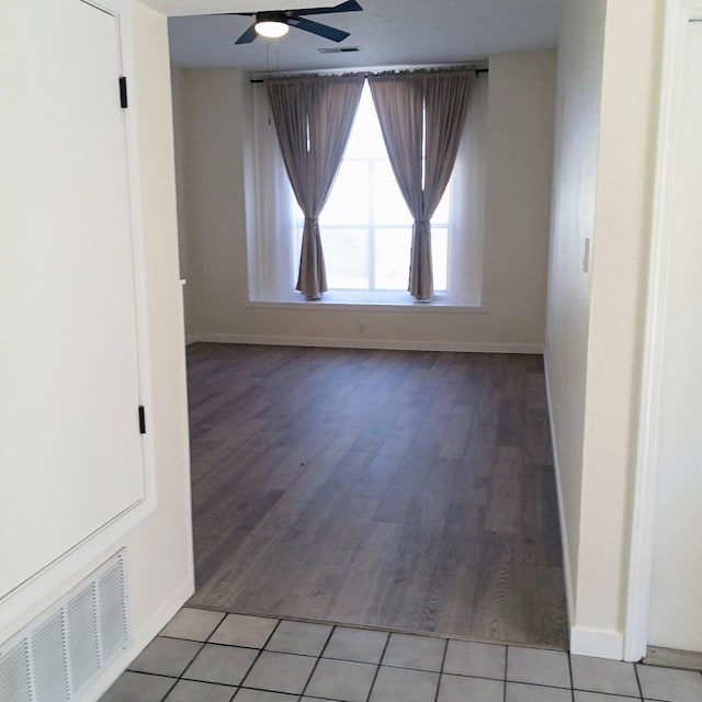 spare room with visible vents, baseboards, light wood-type flooring, and a ceiling fan