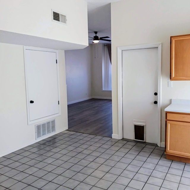 kitchen with light tile patterned floors, visible vents, light countertops, and a ceiling fan