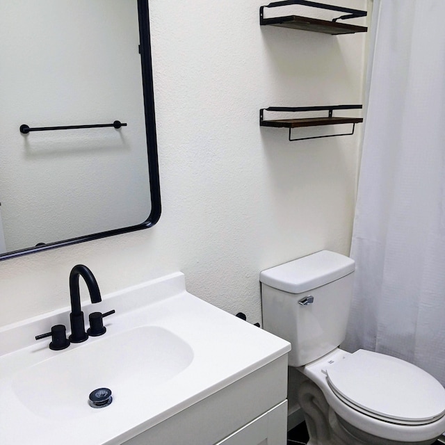 bathroom featuring toilet and vanity