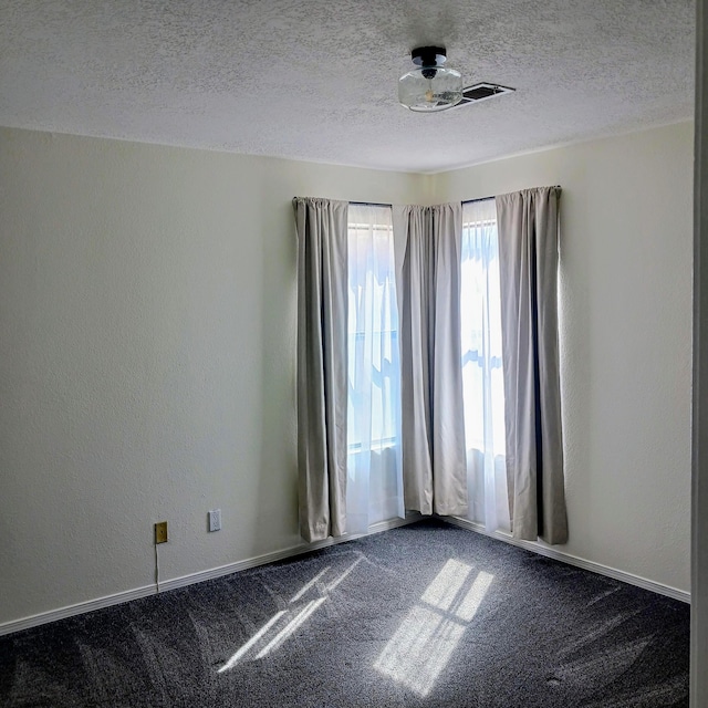 spare room with baseboards, a textured ceiling, dark carpet, and a textured wall