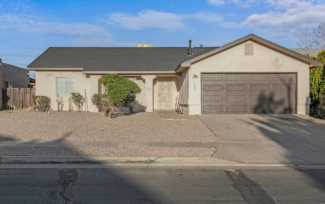 single story home featuring stucco siding, an attached garage, driveway, and fence