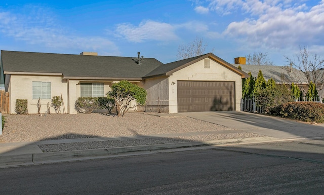 single story home with stucco siding, an attached garage, and concrete driveway