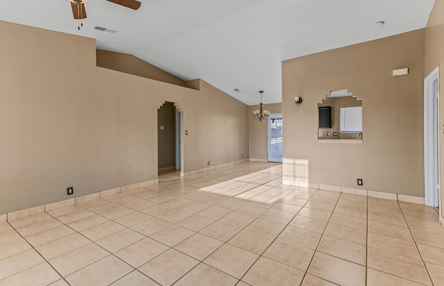 empty room with light tile patterned floors, visible vents, ceiling fan with notable chandelier, and vaulted ceiling