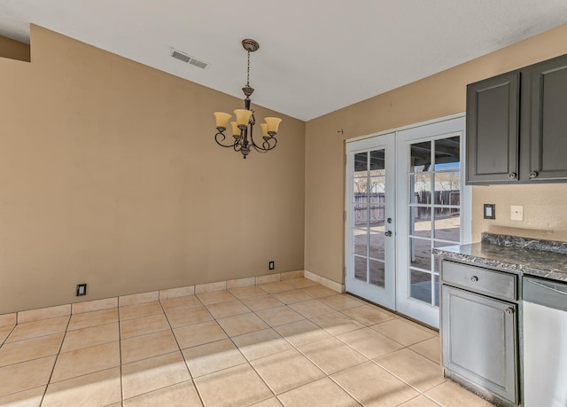 unfurnished dining area with visible vents, lofted ceiling, light tile patterned floors, french doors, and a notable chandelier