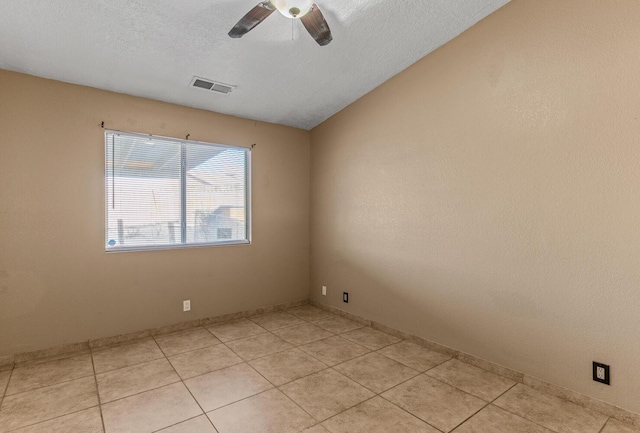 empty room featuring light tile patterned floors, visible vents, a textured ceiling, and a ceiling fan