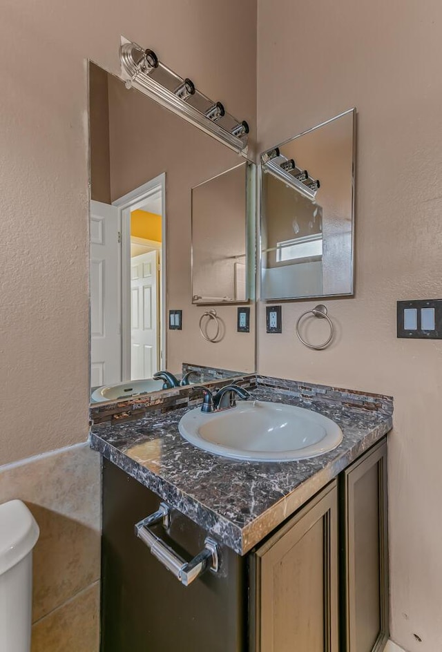 half bathroom featuring toilet and vanity