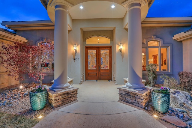 view of exterior entry with stucco siding and french doors