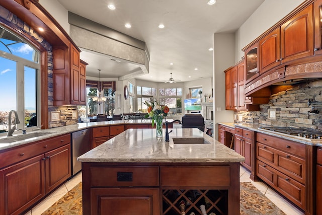 kitchen with a sink, light stone countertops, backsplash, and appliances with stainless steel finishes