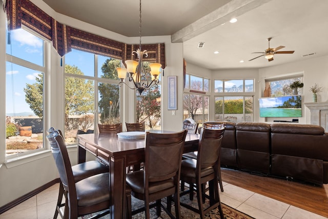 dining space featuring light tile patterned floors, ceiling fan with notable chandelier, and visible vents