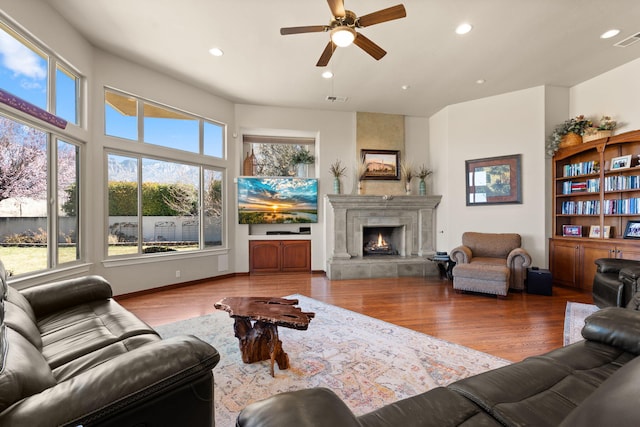 living area with a fireplace, recessed lighting, wood finished floors, and ceiling fan