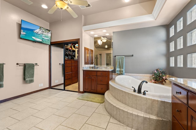 bathroom featuring visible vents, baseboards, ceiling fan, a bath, and vanity