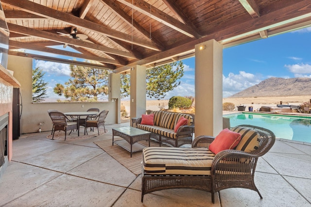 view of patio featuring a fenced in pool, ceiling fan, an outdoor hangout area, outdoor dining area, and a mountain view