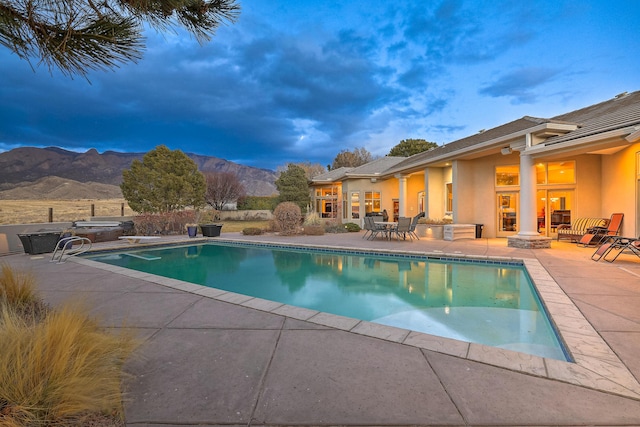 view of pool featuring a fenced in pool, a diving board, a fire pit, a patio area, and a mountain view