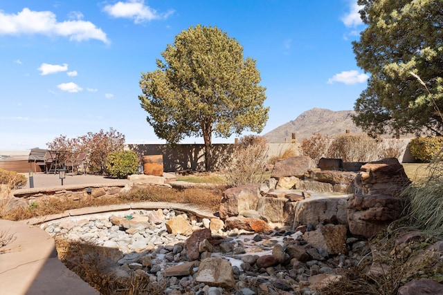 view of yard featuring fence and a mountain view