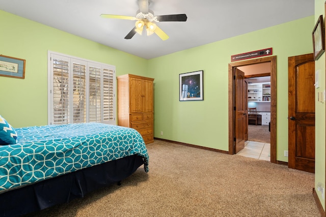 bedroom featuring light colored carpet, a ceiling fan, and baseboards