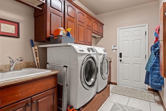 washroom with baseboards, light tile patterned flooring, cabinet space, a sink, and independent washer and dryer