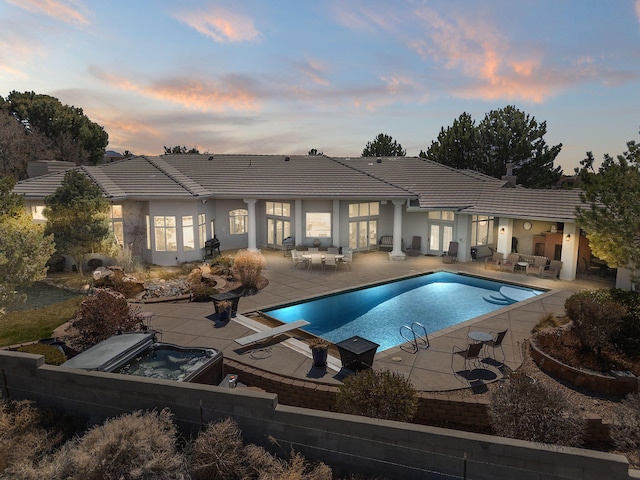 view of swimming pool with a hot tub and a patio