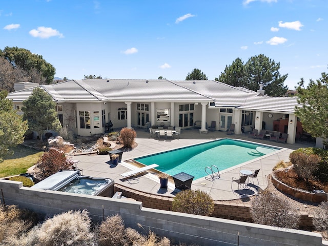 view of pool with outdoor lounge area, an in ground hot tub, french doors, and a patio area