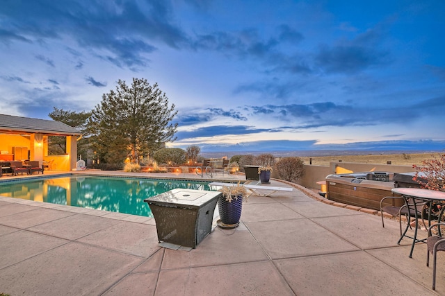 view of swimming pool featuring a patio area, a fenced in pool, and a hot tub