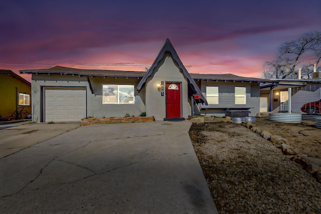 view of front of house featuring stucco siding, concrete driveway, and an attached garage