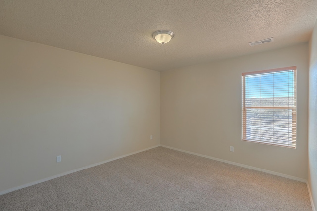 unfurnished room featuring baseboards, visible vents, carpet floors, and a textured ceiling