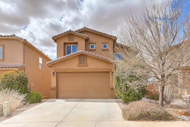 view of front of property with stucco siding, concrete driveway, an attached garage, and a tile roof