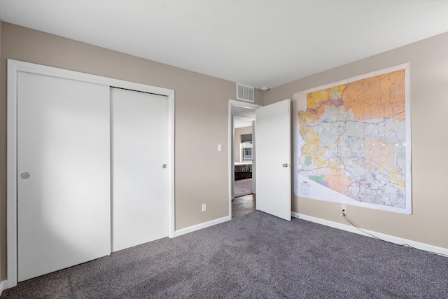 unfurnished bedroom with a closet, visible vents, carpet flooring, and baseboards