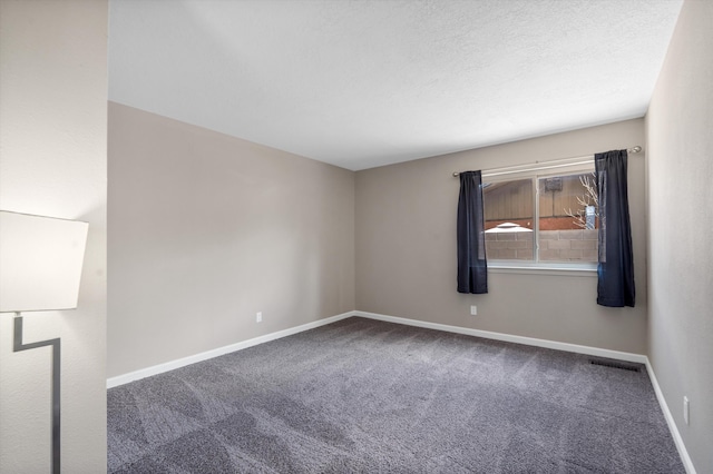 carpeted empty room featuring visible vents, baseboards, and a textured ceiling