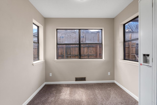 carpeted empty room with baseboards and visible vents