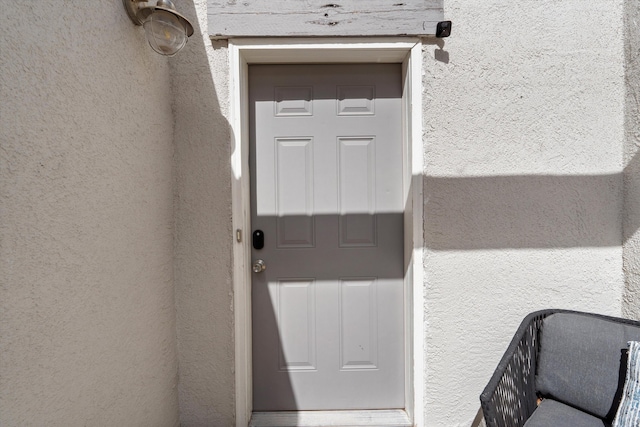 view of exterior entry with stucco siding