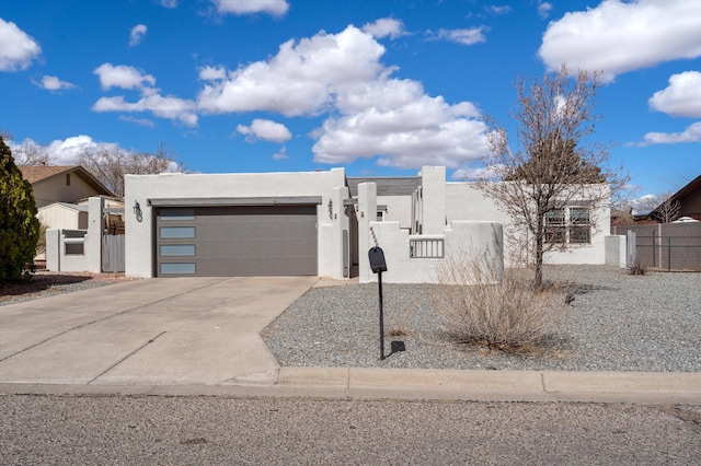 view of front of property featuring a fenced front yard, stucco siding, an attached garage, and concrete driveway