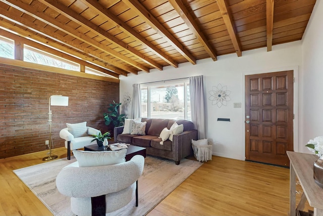 living area featuring light wood-type flooring, vaulted ceiling with beams, wooden ceiling, and brick wall