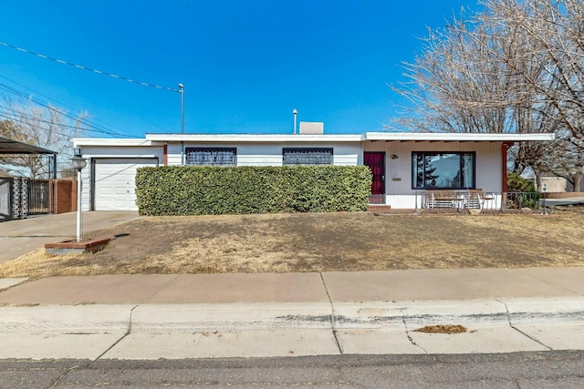 single story home with a garage, covered porch, and driveway