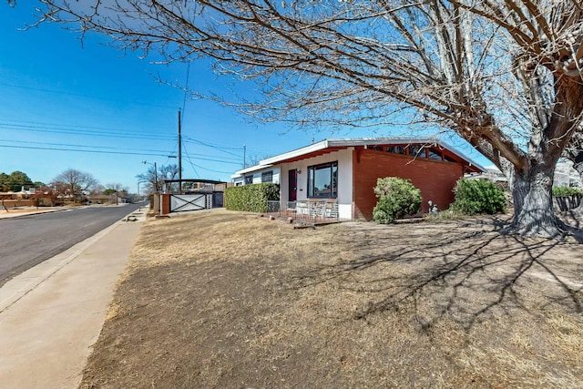 view of front of home featuring brick siding and a gate