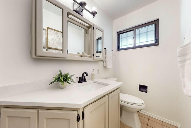 bathroom featuring tile patterned flooring, toilet, vanity, and baseboards