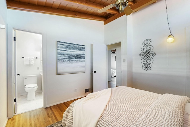 bedroom with beamed ceiling, ensuite bathroom, wooden ceiling, light wood finished floors, and baseboards