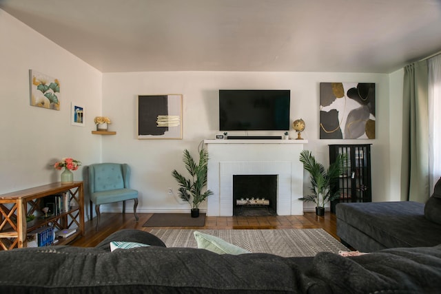 living room featuring baseboards, wood finished floors, and a fireplace