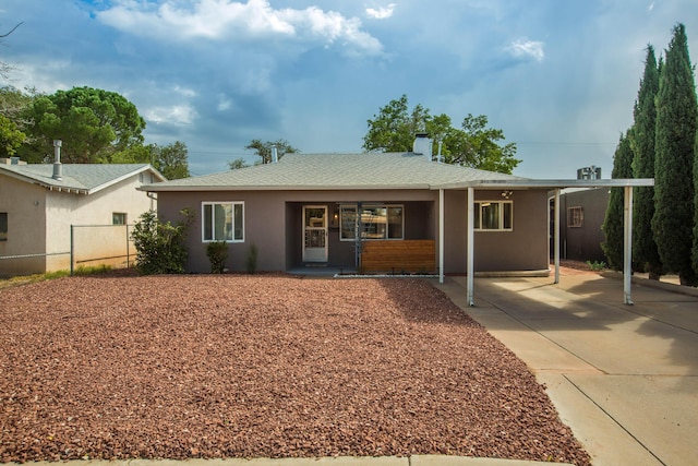 ranch-style house featuring stucco siding, roof with shingles, a chimney, and fence