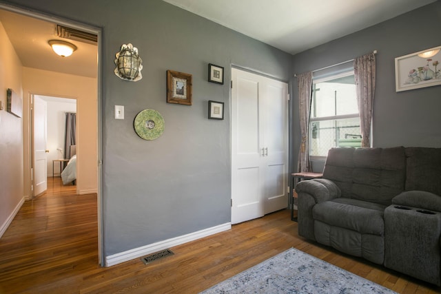 living room with visible vents, baseboards, and wood finished floors