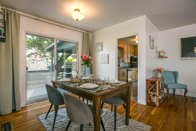 dining area featuring visible vents, baseboards, and wood finished floors