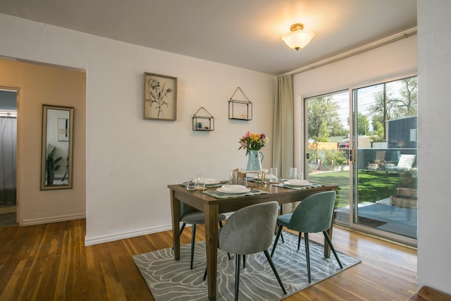 dining space with baseboards and wood finished floors