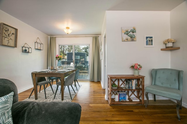 dining space with baseboards and wood finished floors