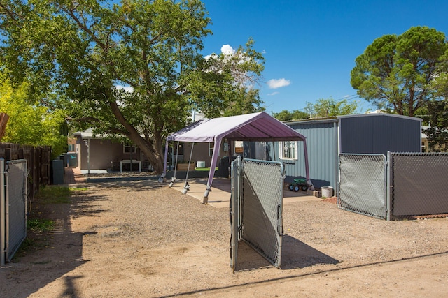 exterior space with a carport, a gate, and fence