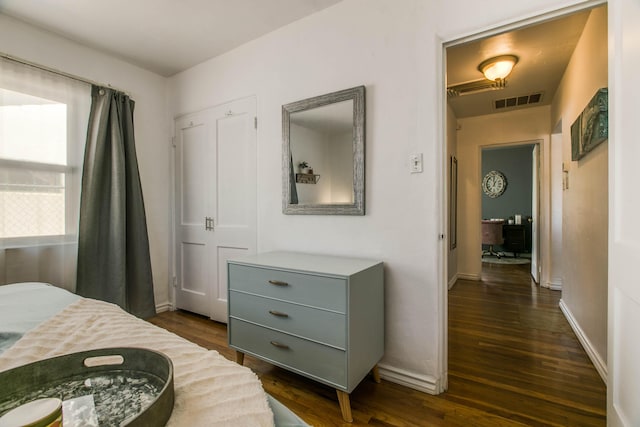 bedroom featuring dark wood-type flooring, baseboards, and visible vents